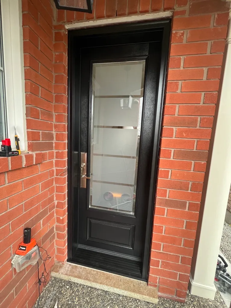 Black entry door with a tall frosted glass insert