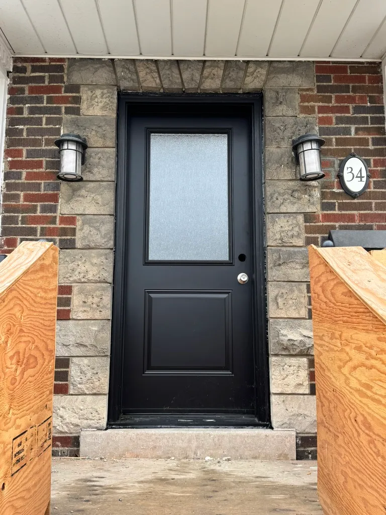 Black entry door with a tall frosted glass panel