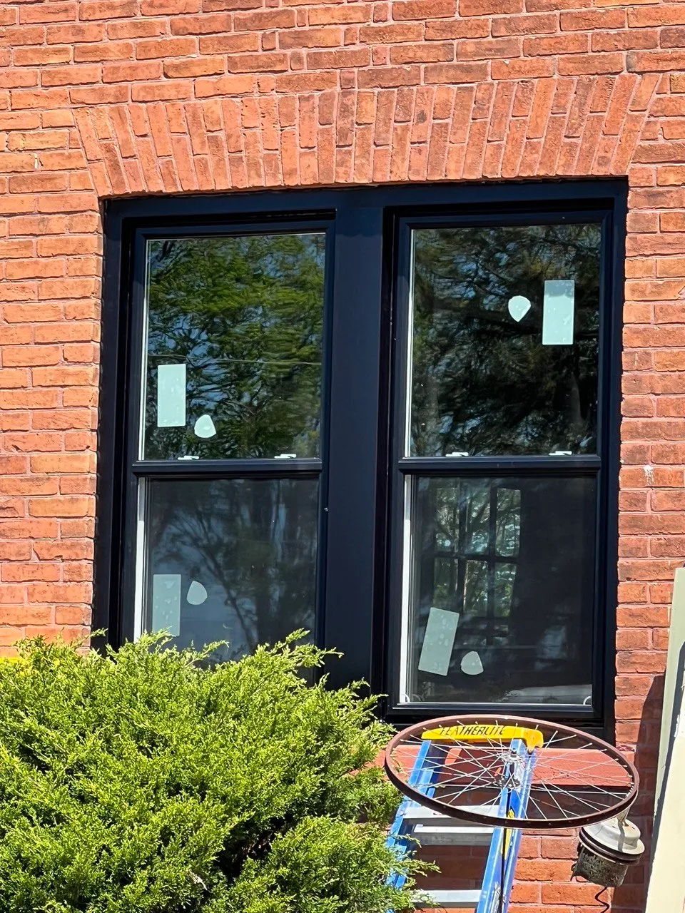 Two tall black-framed windows in a red brick wall