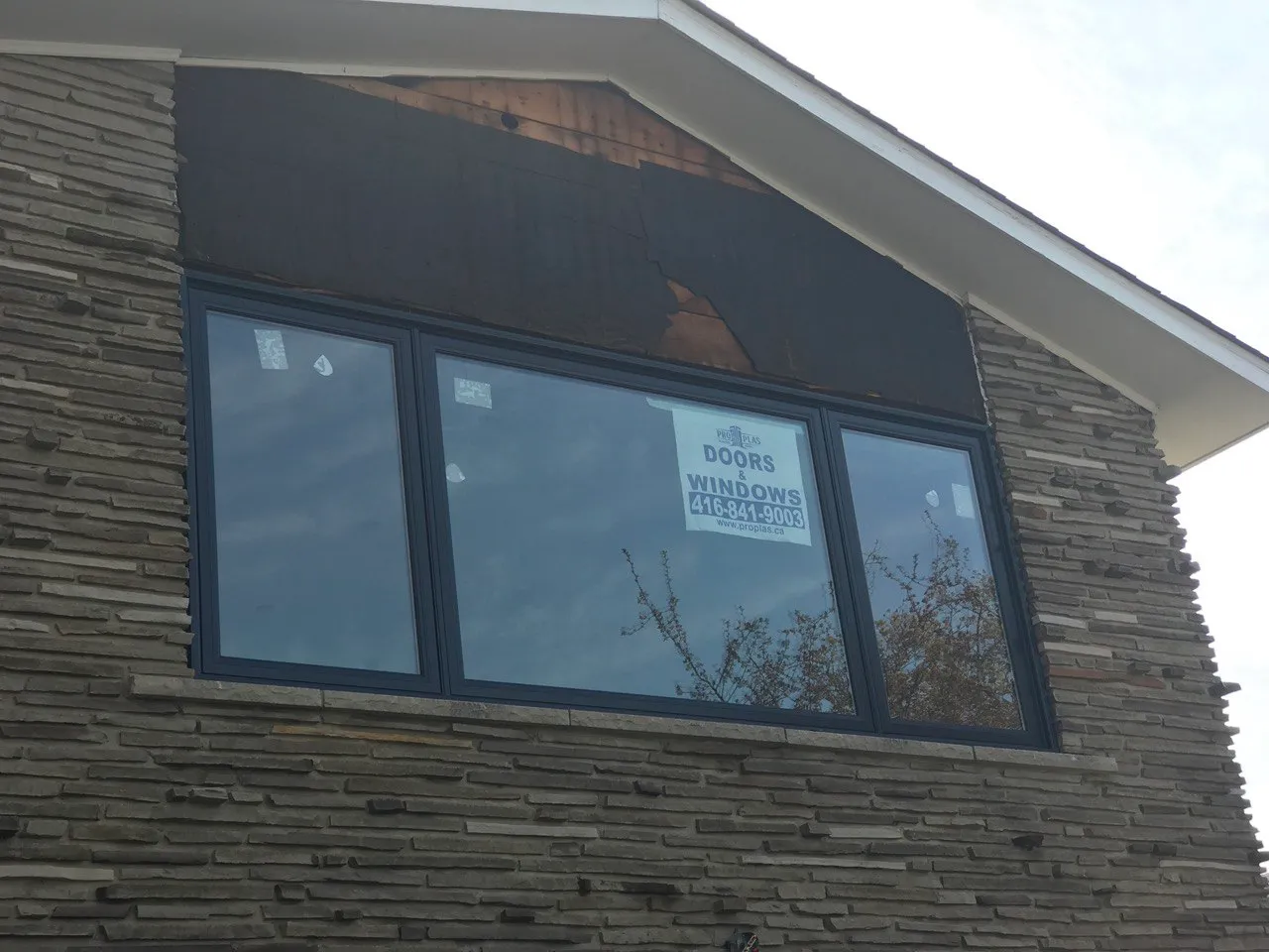 Wide black-framed window in a stone exterior wall