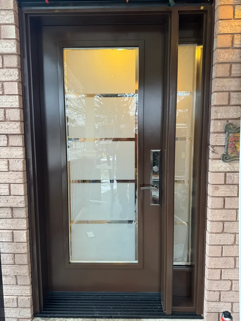 Brown entry door with broad glazing and a narrow sidelight