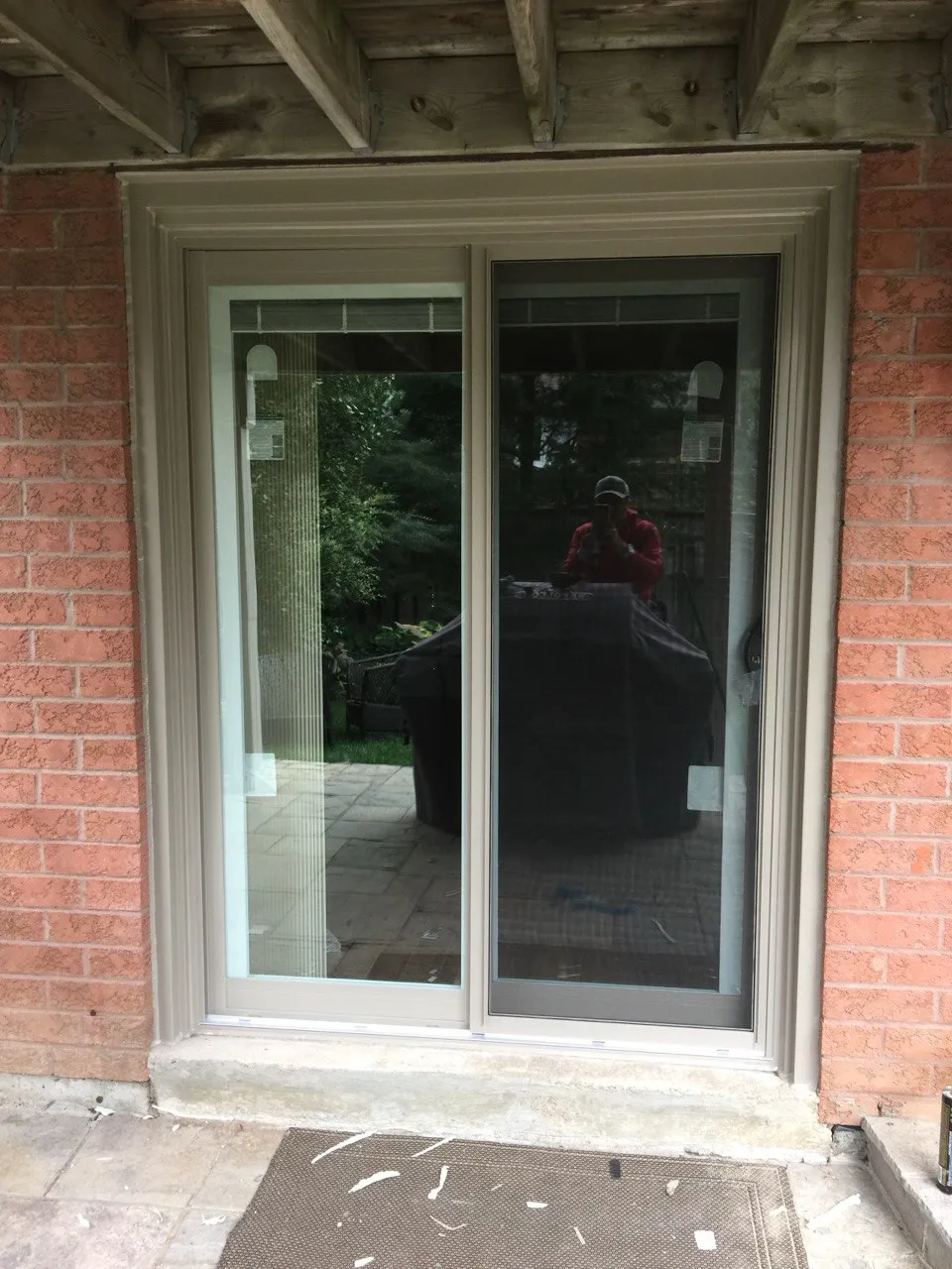 Dark-framed patio sliding door in a brick wall