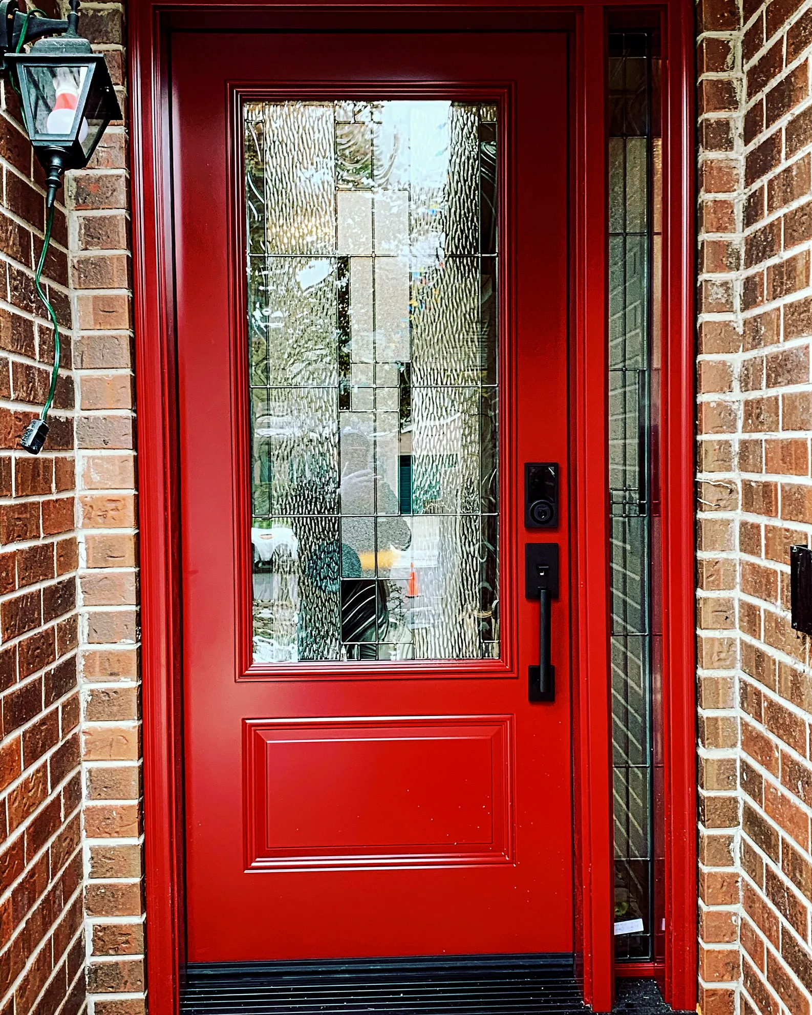 Red entry door with a tall decorative glass insert
