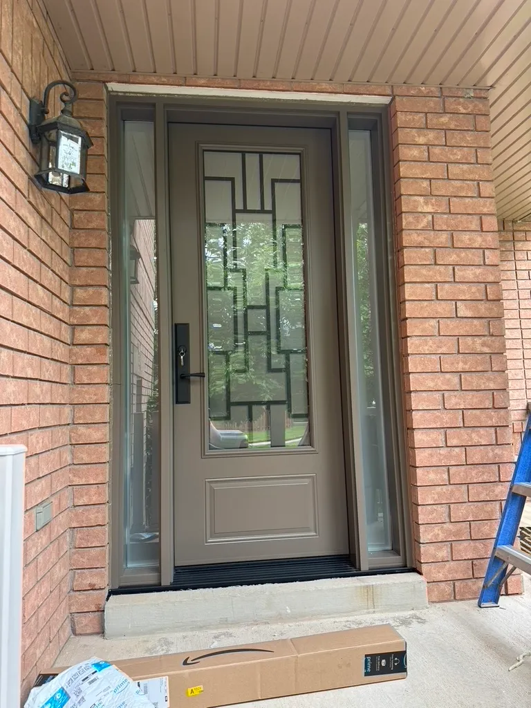Taupe entry door with geometric decorative glass and two sidelights