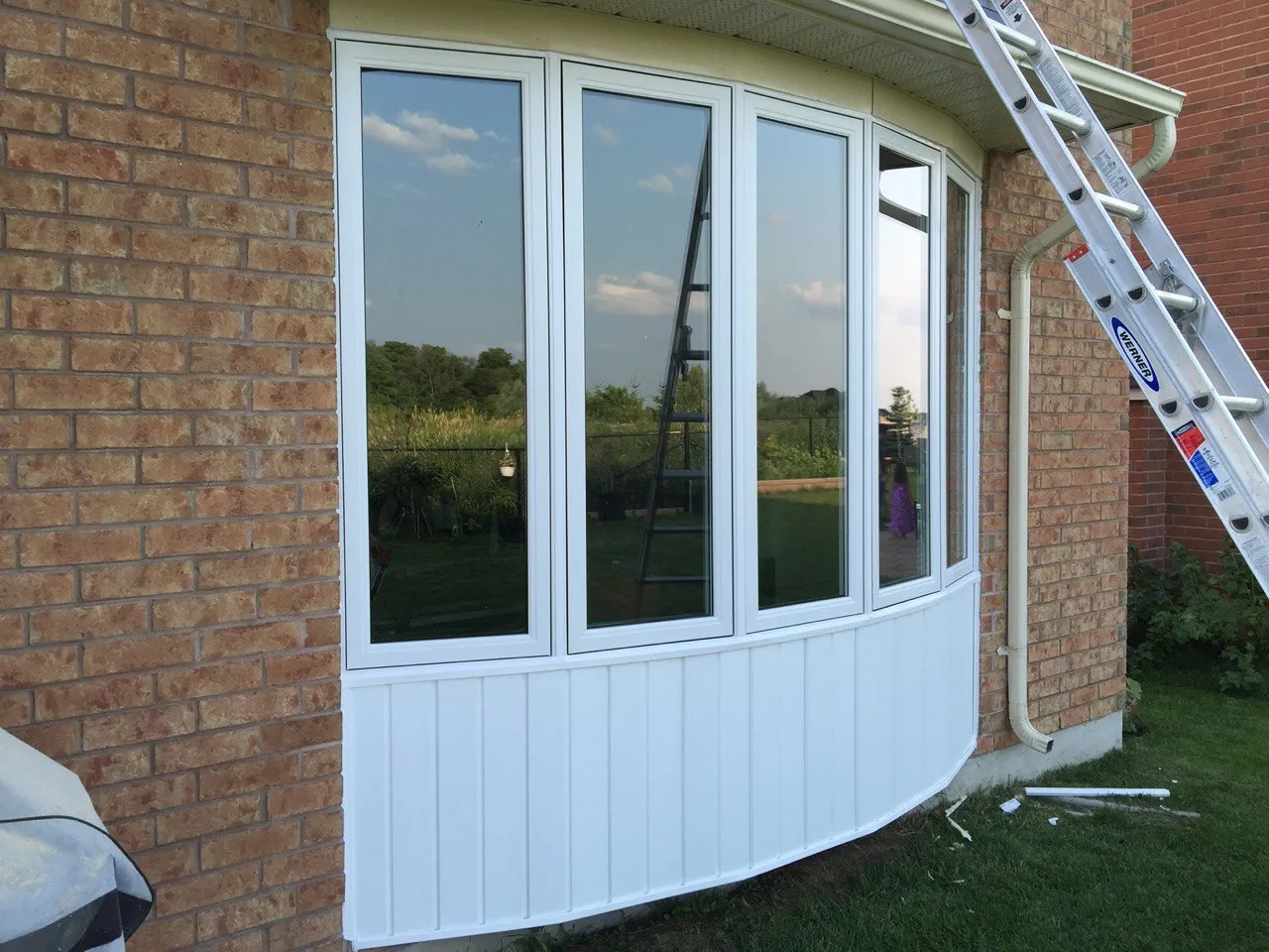 White-framed bay window in a brick exterior wall