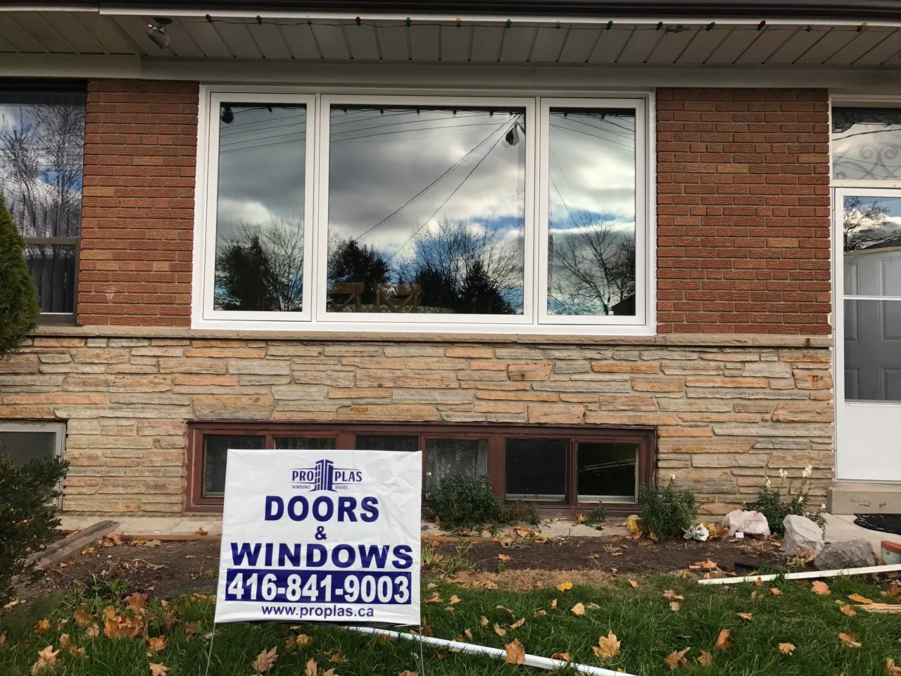 Wide white window combination in a brick and stone facade