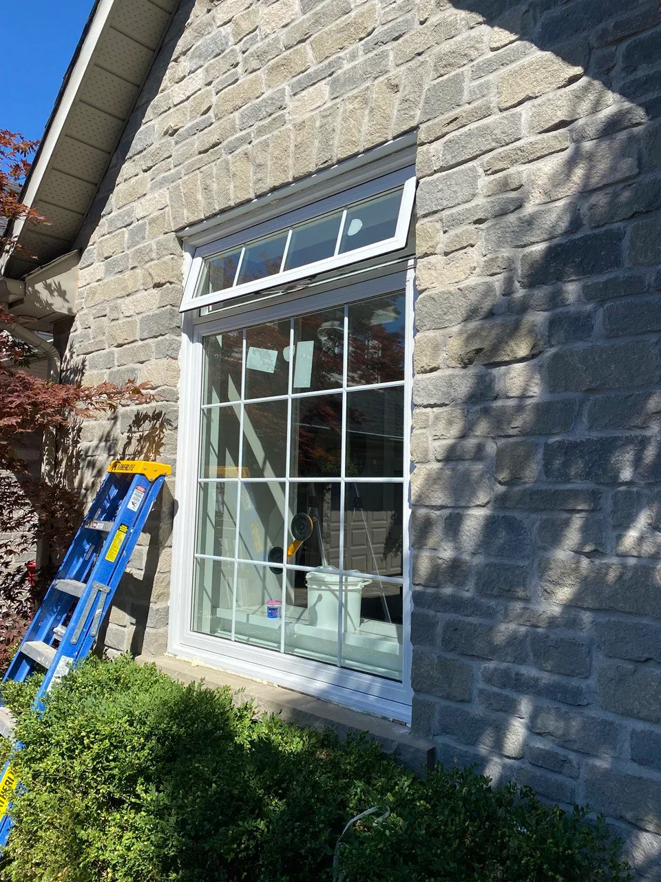 White-framed window in a stone exterior wall