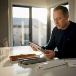 Homeowner examining window frame samples at dining table
